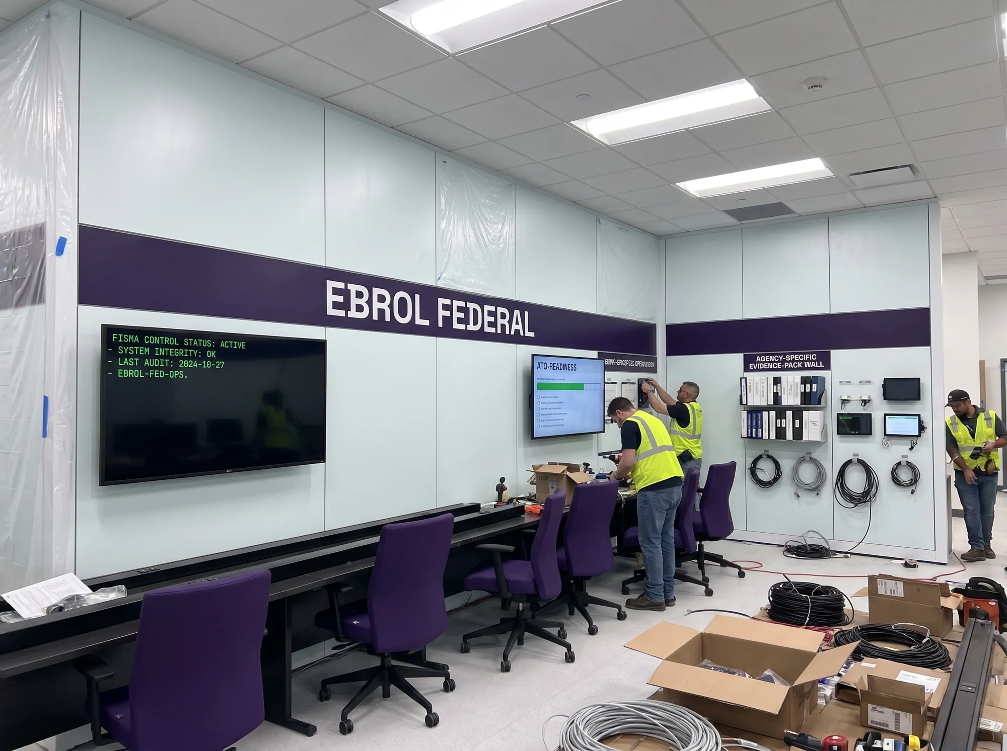Ebrol Federal Operations Center (Environmental) — A working public-sector operations-center build-out — working FISMA-control working monitor, working ATO-readiness working display, working agency-specific working evidence-pack working wall, deep violet wordmark band.
